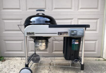 Full view of Weber 22 inch Performer Deluxe Charcoal Grill in front of Eric's garage. We reviewed the model with a black lid.